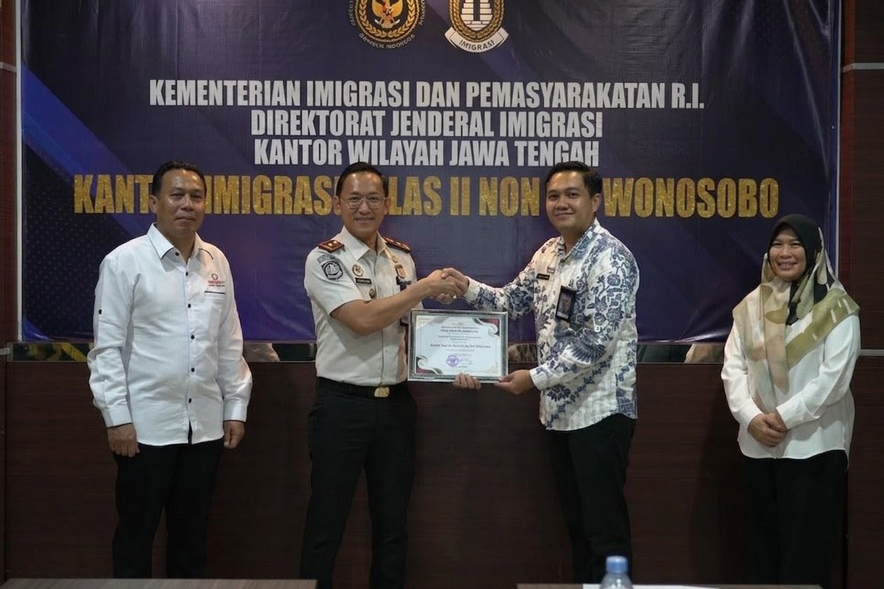 Tolong edit foto ini tanpa merubah karakter orang dalam foto. Posisi piagam disodorkan maju agar lebih jelas